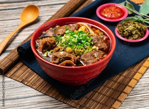Hot beef soup green onion and chili sauce served in a bowl isolated on table top view of taiwanese food