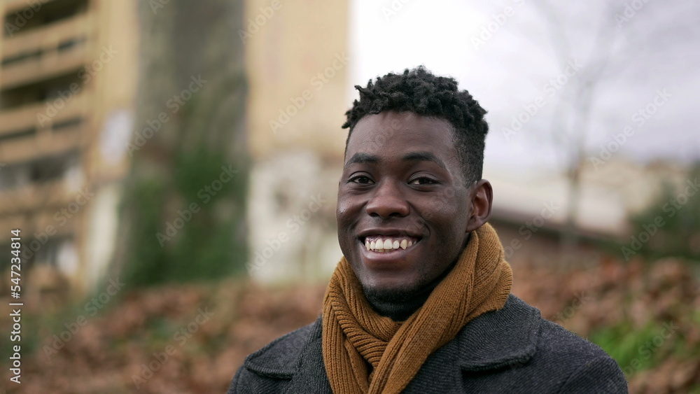 Happy black African man looking at camera smiling portrait during winter season2 Happy black African man looking at camera smiling portrait during winter season2