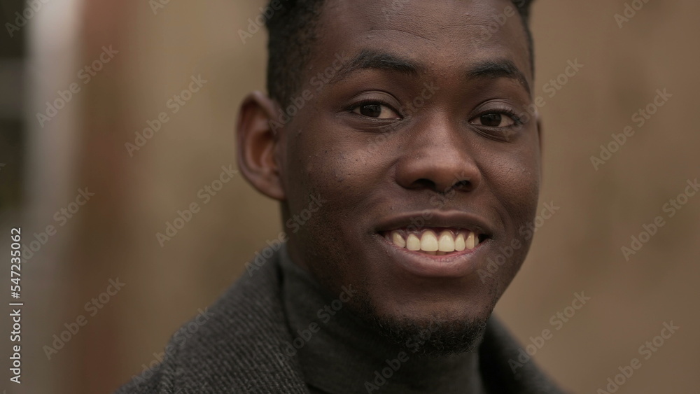 Friendly young black man smiling at camera. Charismatic handsome African person Friendly young black man smiling at camera. Charismatic handsome African person