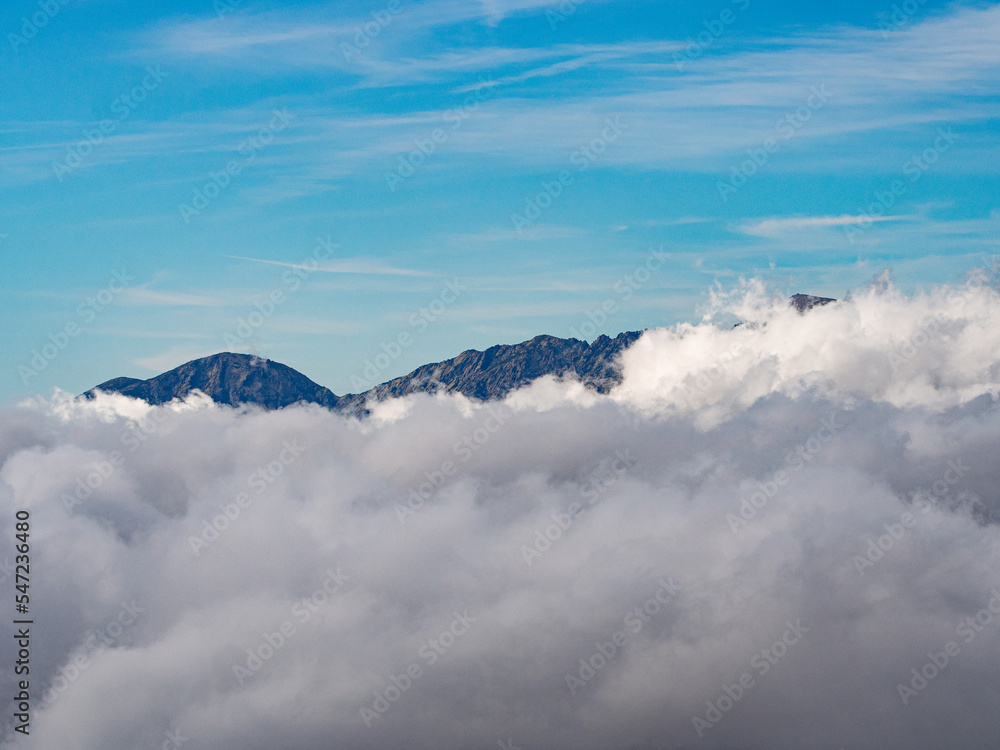 mountain peaks behind clouds