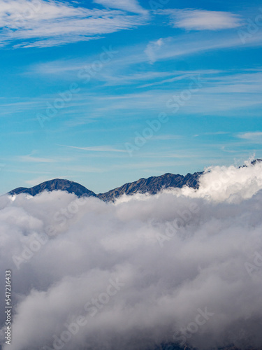 mountain peaks behind clouds