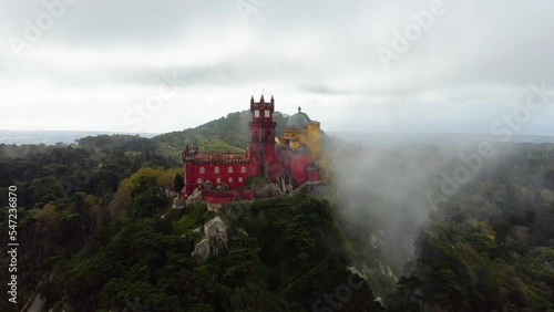 Aerial drone view of Park and National Palace of Pena in Sintra, Portugal during a foggy day. Unesco. Historic visits. Sightseeing. Fairytale. Best destinations in the world. Most visited places. 
