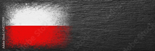 Flag of Poland. Flag is painted on black slate stone. Stone background. Copy space. Textured background