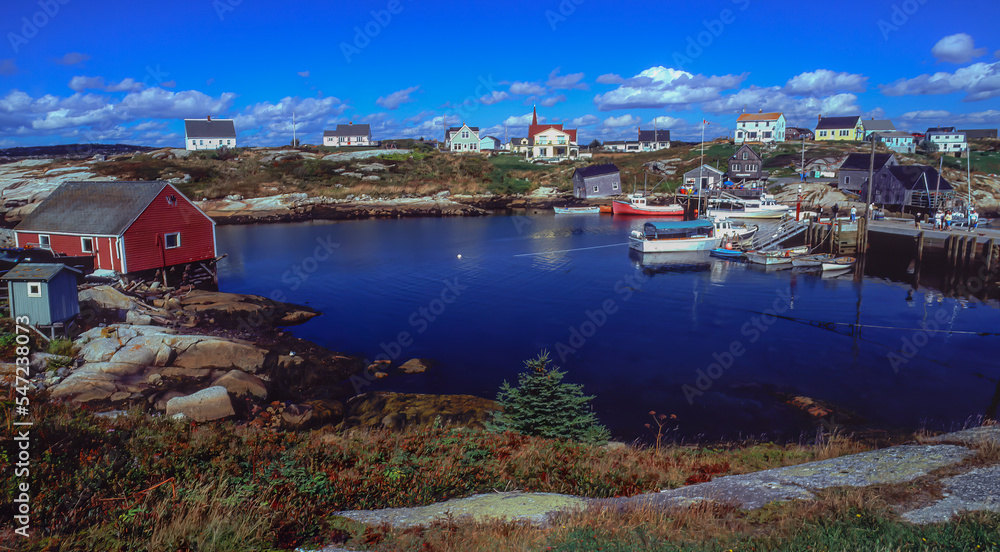 Fishing boat moorage and colorful homes at Peggys Cove Nova Scotia.  Peggys Cove is a small rural community located on the eastern shore of St. Margarets
