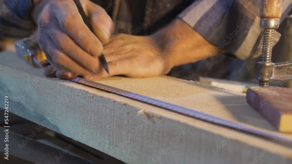 Measuring with meters. Wood measurement. The carpenter measures the wood with the meter and