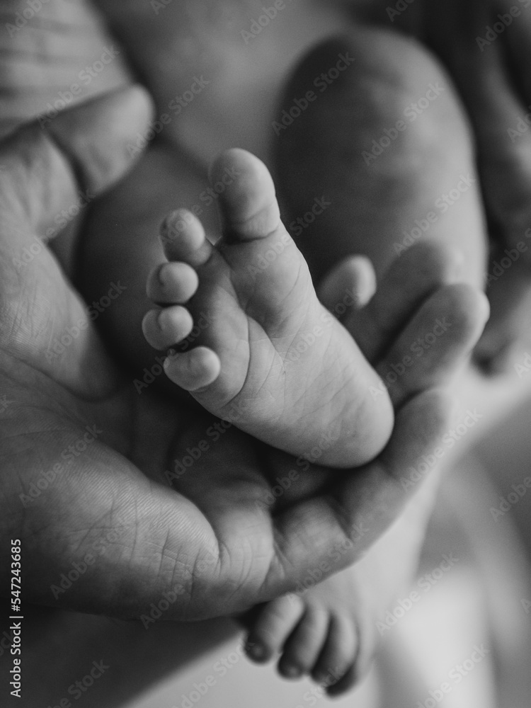 child's foot held by parent (selective focus and noise)