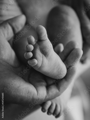 child's foot held by parent (selective focus and noise)