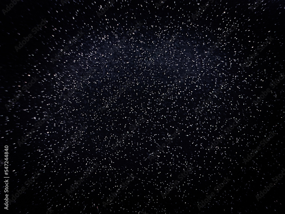 Fototapeta premium Blurred dots on black background. Dark texture with particles