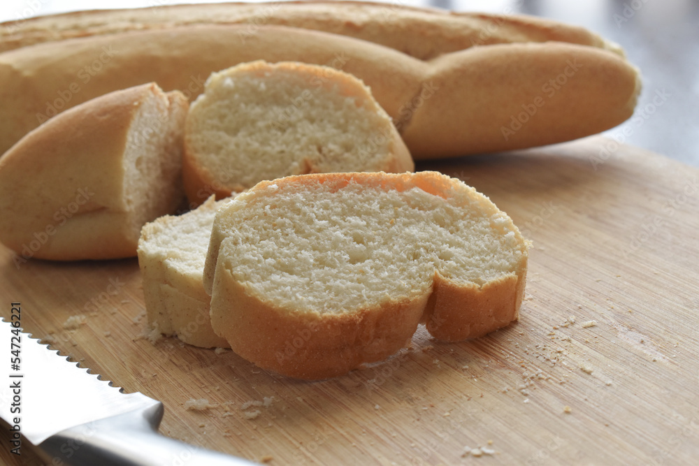 Baguette on a bamboo chopping board. French bread on a cutting board. 