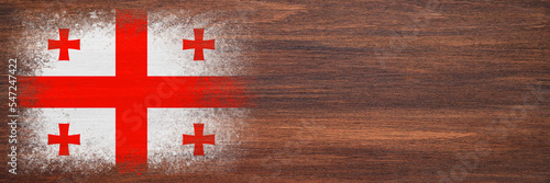 Flag of Georgia. Flag is painted on a wooden surface. Wooden background. Plywood surface. Copy space. Textured background