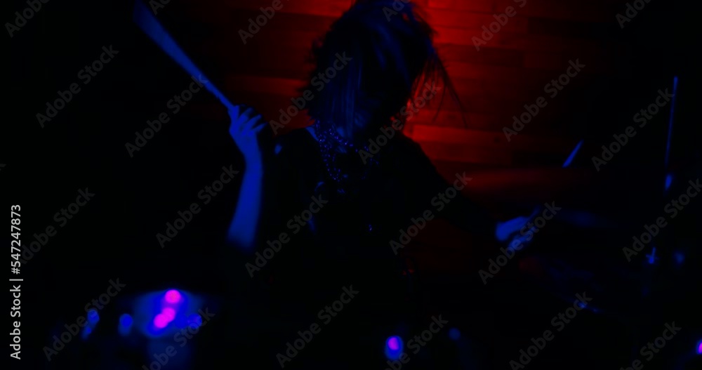 Light turns on, the drummer girl make a trick with drumsticks and begins to play the drums vigorously. Blue and red strobe lights blink to the beat of the drums. The beginning of the show. Light turns on, the drummer girl make a trick with drumsticks and begins to play the drums vigorously. Blue and red strobe lights blink to the beat of the drums. The beginning of the show.
