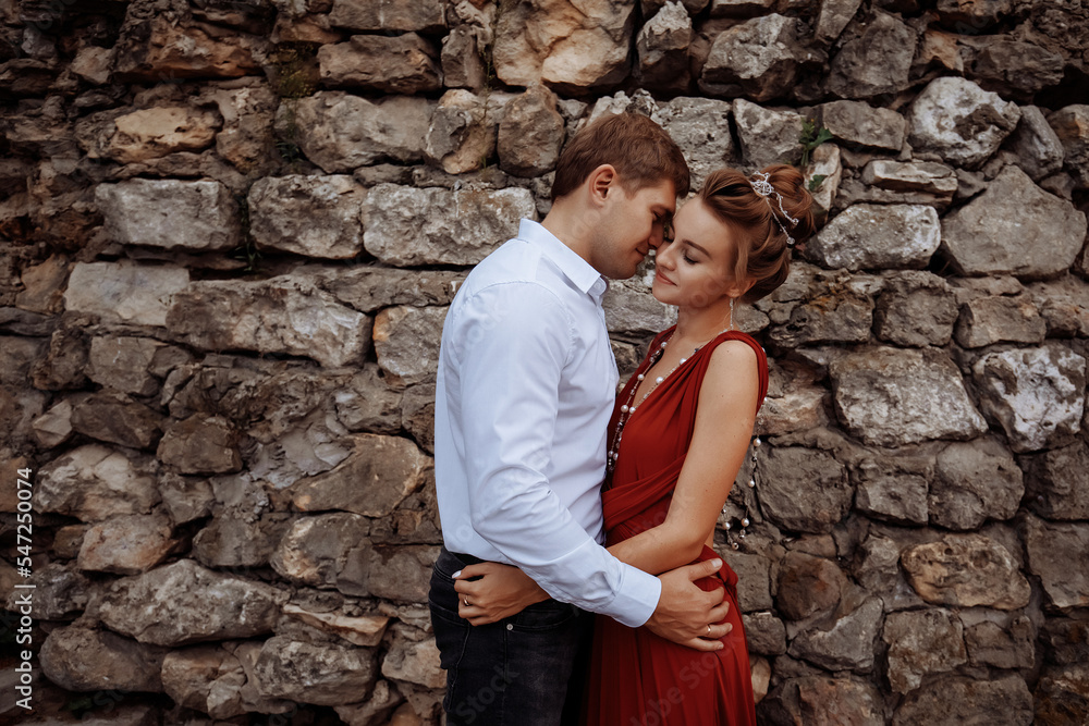 An elegant man in a shirt hugs a slender girl. An elegant man in a shirt hugs a slender girl.