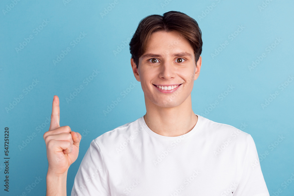 Have you seen this? Handsome young man pointing away looking at camera smile while standing against blue background Have you seen this? Handsome young man pointing away looking at camera smile while standing against blue background