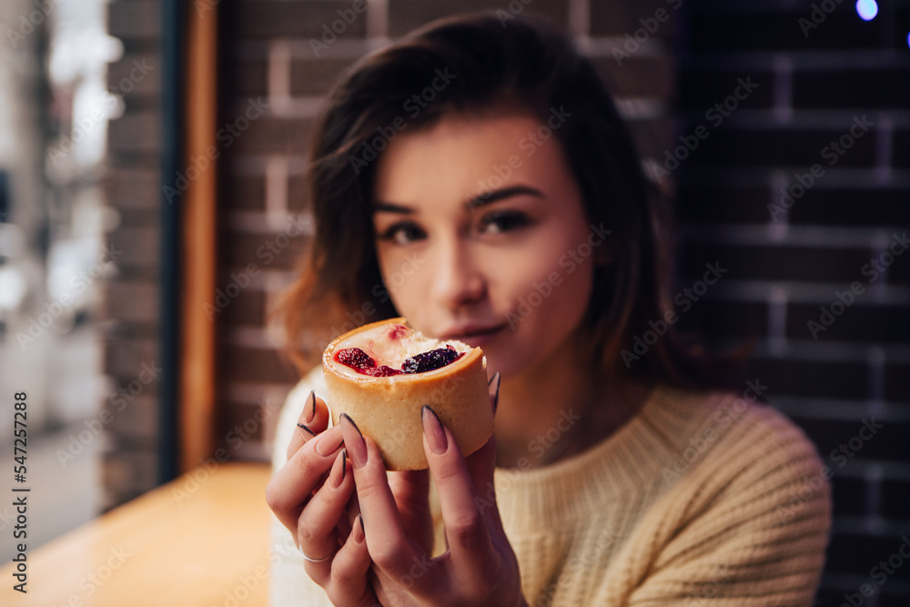 Smiling woman dressed warm sweater, enjoy eating dessert, tasty cupcake. Snack food in street cafe. New Year Christmas decorations, garlands
Smiling woman dressed warm sweater, enjoy eating dessert, tasty cupcake. Snack food in street cafe. New Year Christmas decorations, garlands