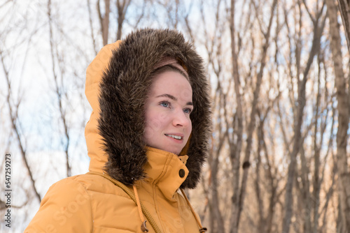 Woman in yellow parka with fur hood closeup portrait