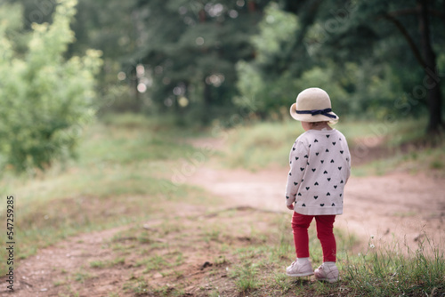 A little girl in a hat walks in the forest, summer, clear day, general plan. © Константин Чернышов