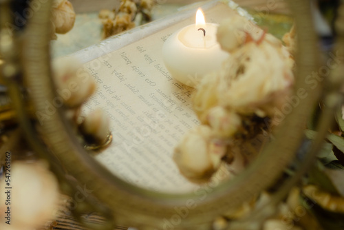 świeczka na starej książce - odbicie w lustrze