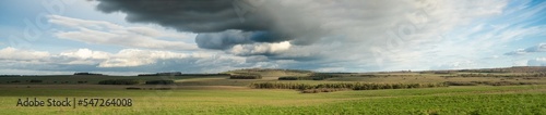 panaoramic view of a dark black shelf cloud bringing heavy rain over a tump, Sidbury Hill, Wiltshire UK