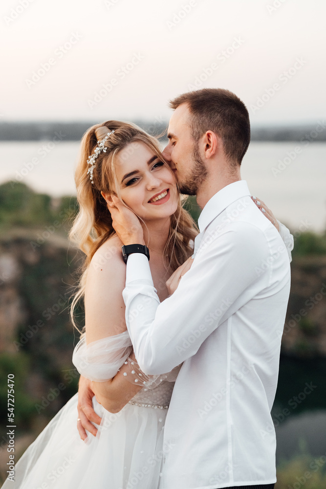beautiful couple in love. stylish groom with the bride in a wedding dress beautiful couple in love. stylish groom with the bride in a wedding dress