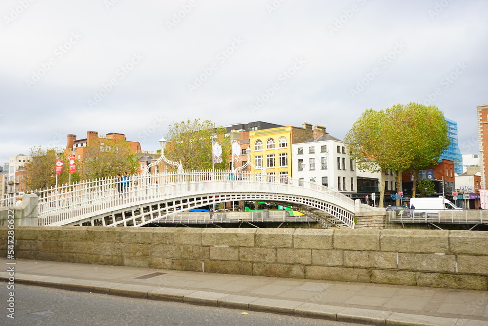 Ha'penny Bridge over River Liffey and City View of Dublin City in Ireland