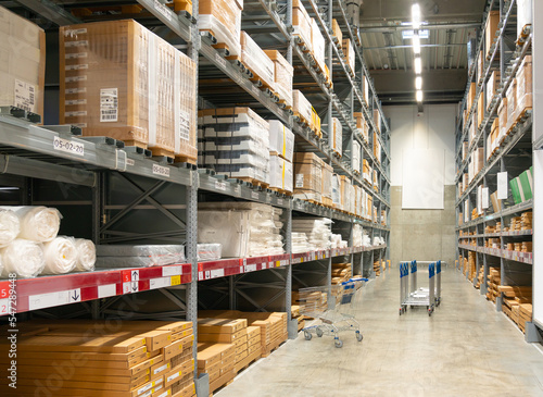 Random shopping carts in a large warehouse in the aisle between shelves and racks