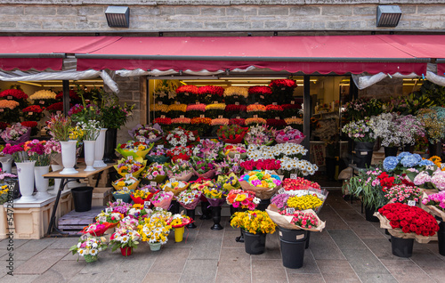Estonia, Tallinn - July 21, 2022: Abundance of colors on flower market along Viru streeet. Covered businesses with bouquets in buckets in front photo