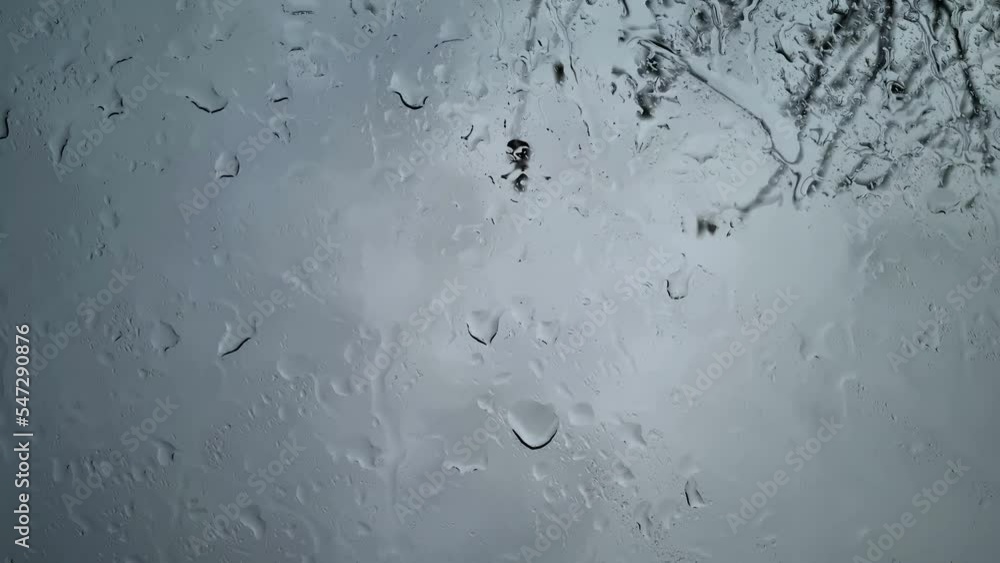 Falling rain water drops motion on a glass during a rainstorm, climate changes weather nature Falling rain water drops motion on a glass during a rainstorm, climate changes weather nature