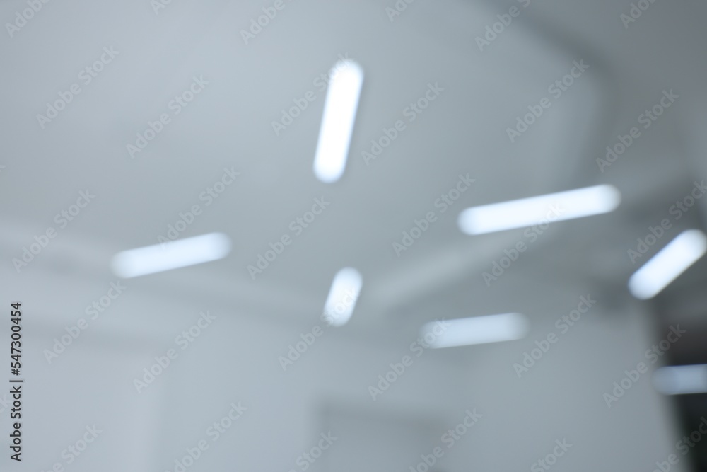 Blurred view of white ceiling with modern lights Blurred view of white ceiling with modern lights
