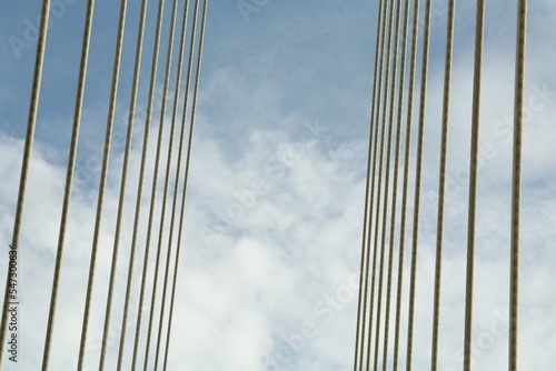 Modern bridge cables against blue sky, low angle view