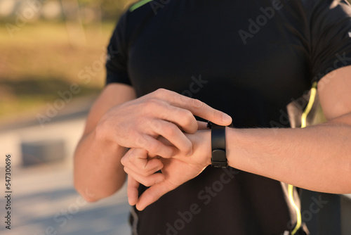 Man checking pulse after training outdoors, closeup. Space for text © New Africa