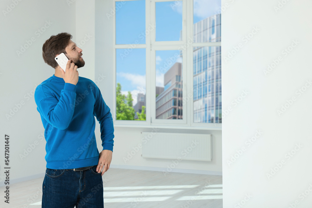 Man in casual clothes talking on phone indoors, space for text Man in casual clothes talking on phone indoors, space for text
