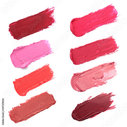 Smears of different beautiful lipsticks on white background, top view
