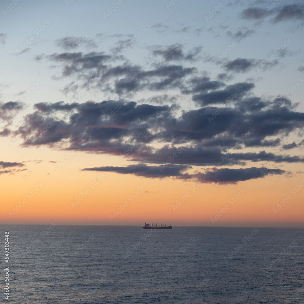 A lonely ship at sea during sunset 