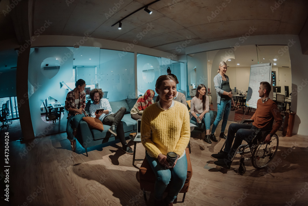 Businesswoman in wheelchair having business meeting with team at modern office. A group of young freelancers agree on new online business projects