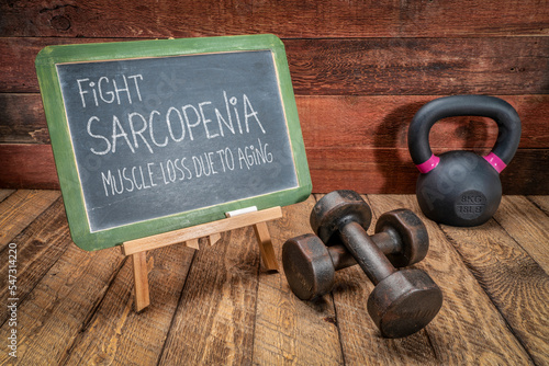 fight sarcopenia, muscle loss due to aging - inspirational message on a blackboard with dumbbells and a kettlebell, senior health and fitness concept photo