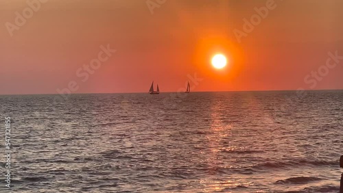 Boats passing by a sunset