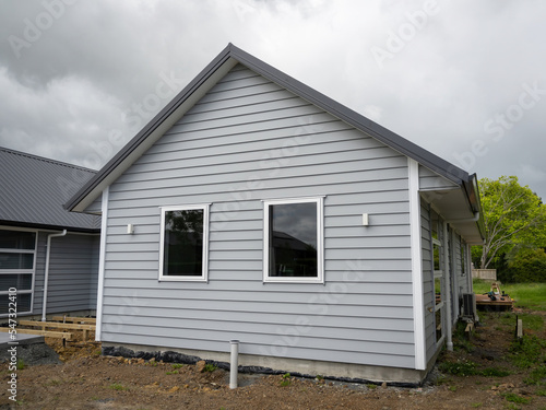 Canvas Print Brand new gray weatherboard house with gable roof and two windows