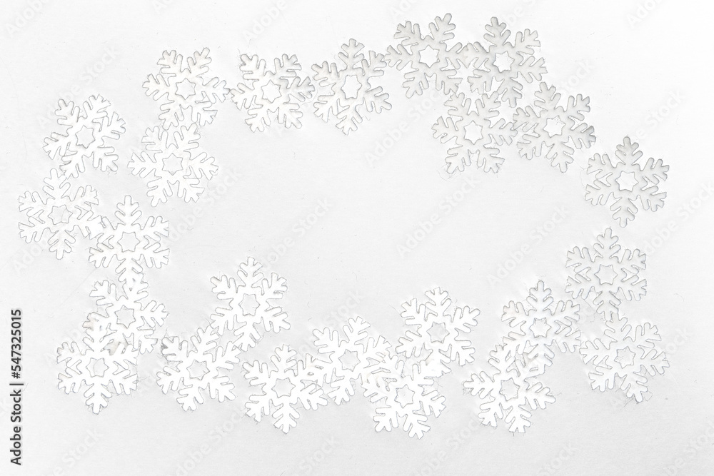 Obraz premium Frame of small white felt snowflakes, celebrating winter holidays 