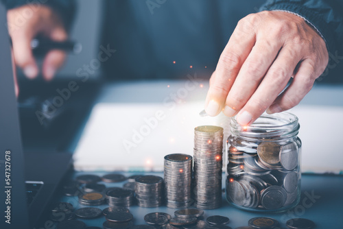 businessman's hand money coins in a glass jar, finance and banking, fund growth and savings concept, proportional money management to spend effectively,Planning for savings for the future