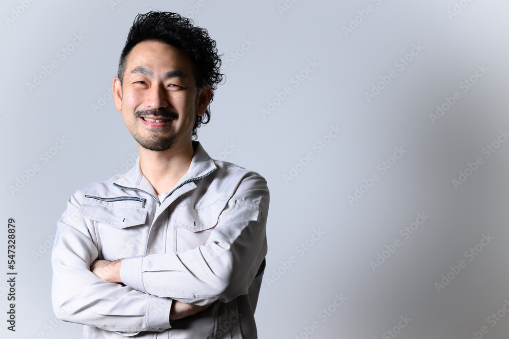 目標に向けてニコニコする作業着姿の経営者 目標に向けてニコニコする作業着姿の経営者