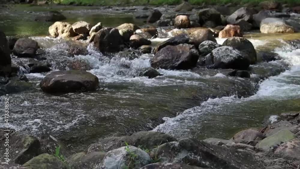 The water in the stream flowed through the rocks, foaming. The water in the stream flowed through the rocks, foaming.