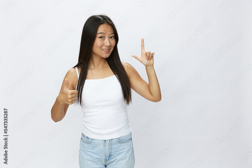 Asian woman hand signals, finger pointing facial skin problems, acne and inflammation, red rash and allergies, chicken pox, sadness from rashes. Facial skin care concept for diseases and nerves Asian woman hand signals, finger pointing facial skin problems, acne and inflammation, red rash and allergies, chicken pox, sadness from rashes. Facial skin care concept for diseases and nerves