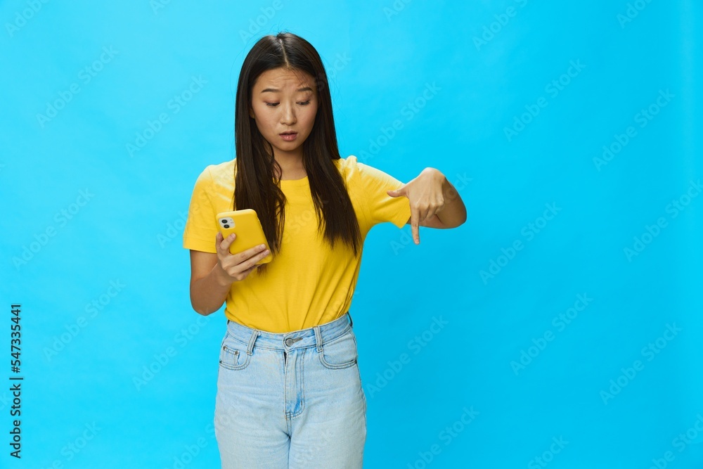 Asian woman traveling with yellow suitcase and tickets with passport in hand, tourist traveling by plane and train with luggage on blue background Asian woman traveling with yellow suitcase and tickets with passport in hand, tourist traveling by plane and train with luggage on blue background