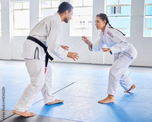 Karate, martial arts and man and woman fight, battle or practice fighting skill during training, workout or fitness challenge. Coach, dojo class and girl learning self defense from taekwondo teacher
