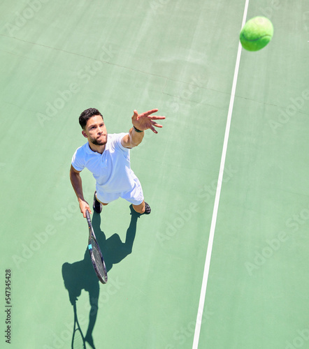 Top view, tennis player and serving ball on tennis court fitness game, workout match or competition exercise. Sports athlete, man and throwing tennis ball in energy cardio training or health wellness © Irshaad M/peopleimages.com