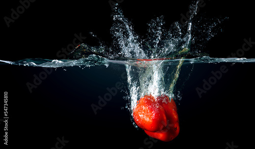 Red pepper in water with splashes