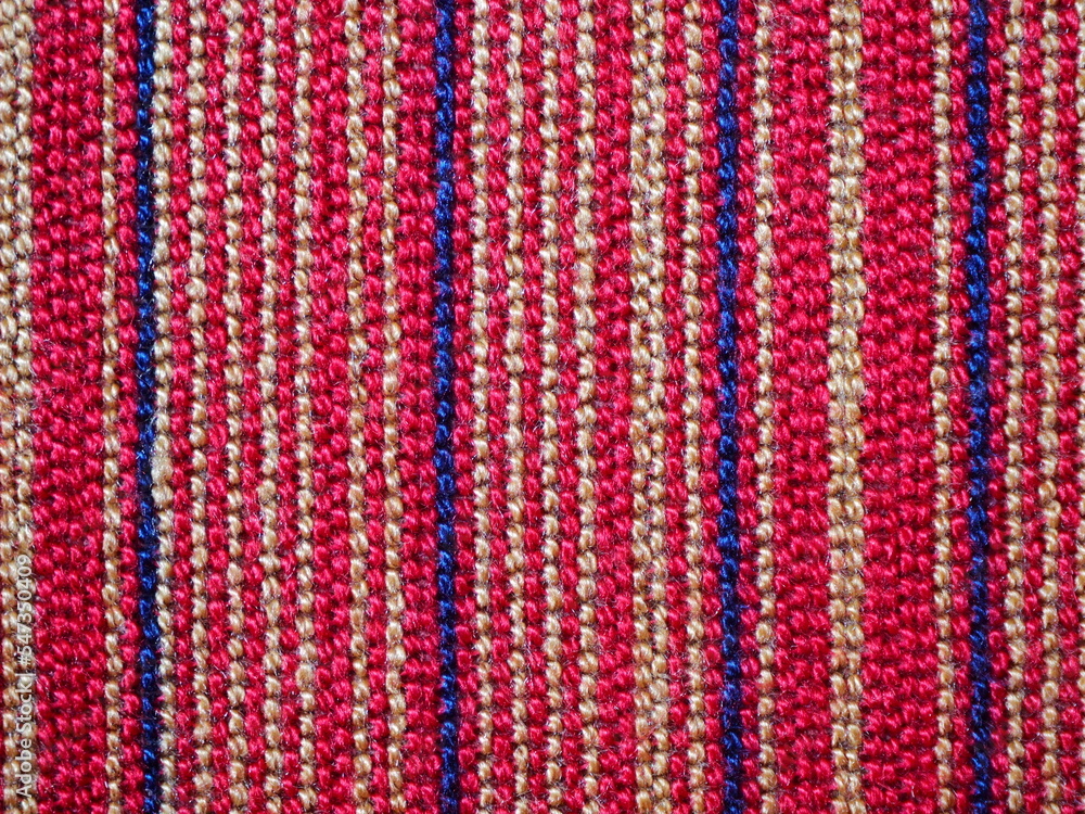 A piece of fabric placemat with colourful (red, navy, beige) pattern line. A piece of fabric placemat with colourful (red, navy, beige) pattern line.