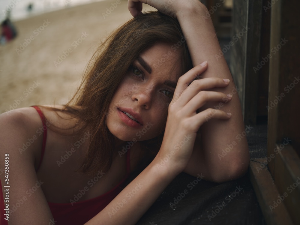 Obraz premium Young woman with a sad look looks into the camera portrait on the beach on a summer vacation trip to the sea
