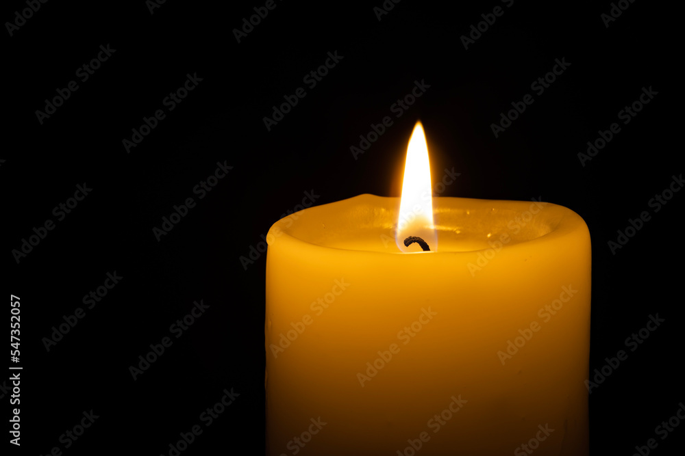 a burning candle on the black backgrounds a burning candle on the black backgrounds