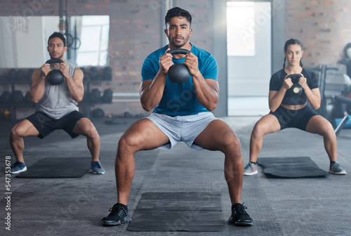 Fitness, kettlebell and personal trainer with a man coach training a class in the gym for health. Exercise, workout and bodybuilder with a male athlete teaching students in a club for strong muscles